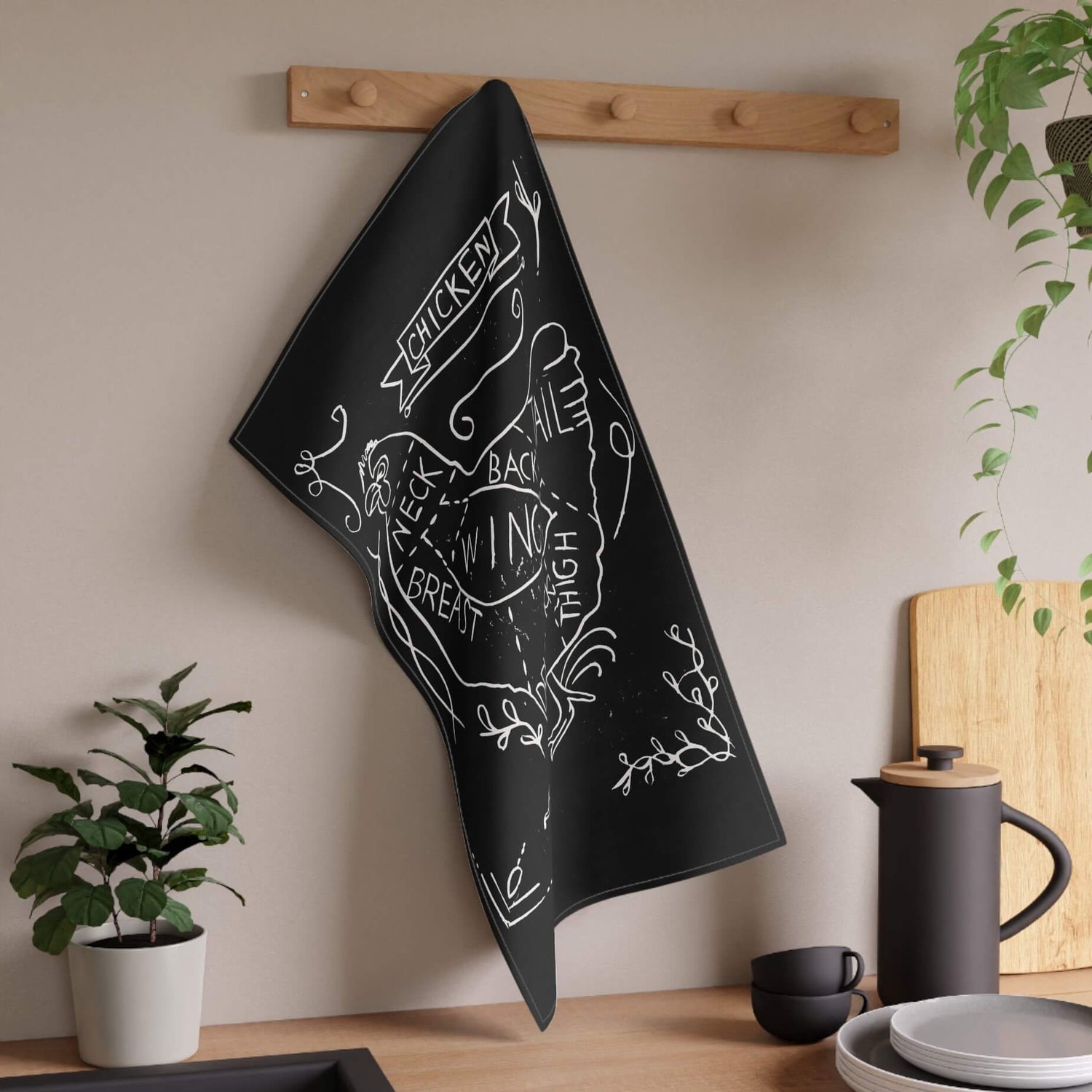 kitchen towel hung on a wall in a kitchen with a digitally edited lino print black with a chicken meet cut diagram